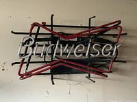 Full view of broken Budweiser bowtie neon sign on wall