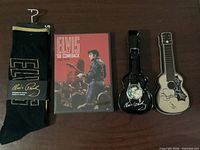 Full view of socks, DVD, watch in guitar case, extra guitar case lid