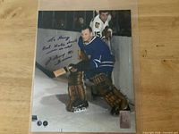 Full view of signed 8×10 photo in sleeve on table