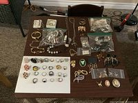 Full lot overview on table showing rings, bracelets, necklaces, earrings and brooches
