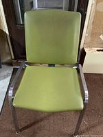 Front view showing olive green vinyl seat/back and chrome frame with arms