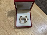 Gold ring in presentation box, top view showing rectangular setting