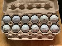 Open carton displaying 12 white Titleist Pro V1 golf balls