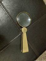 Magnifier folded out showing lens and handle front