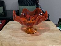 Front view of Viking persimmon amber 6-petal glass compote on pedestal