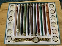 Full box showing 13 straps, 12 bezel rings, watch with leopard strap