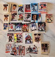 Assorted hockey trading cards stacks and singles spread on table