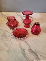 Group shot of all four cranberry glass items