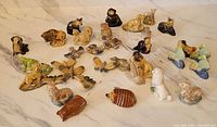 Group shot of all 34 Wade Red Rose Tea porcelain animal figurines on marble surface