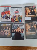 Front covers of six DVD cases showing Big Bang Theory Seasons 8-10 and NCIS Seasons 1-2