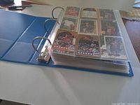 Closed blue binder with visible pocket pages of basketball cards