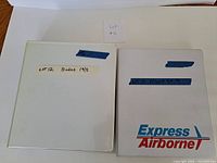 Front view of two white binders, one plain, one Express Airborne