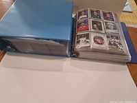 Both binders closed and one open to show card layout