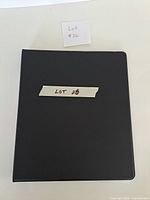 closed black binder labeled Lot 26