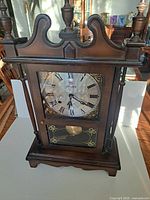 Front view of Citizen wooden pendulum wall clock showing entire case and dial