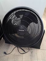 Front view of black Honeywell TurboForce floor fan showing circular grill and logo