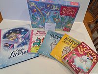 Group shot of five French children’s books and Usborne unicorn puzzle box