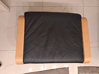 Top view of Poang footstool showing black cushion and birch frame