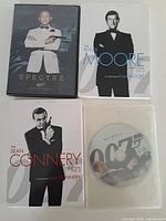 Overview of four DVD items including Spectre, Skyfall disc, Moore and Connery collections