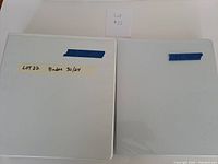Two white 3-ring binders closed, front view
