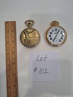 Front views of both pocket watches beside ruler