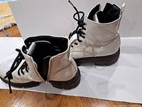 Both Skechers white ankle boots showing exterior, laces, side zippers and soles