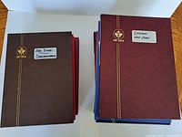 Stack of ten Uni-Safe stamp albums showing covers and labels
