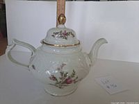 Left side view showing floral decoration, handle, ruler for scale