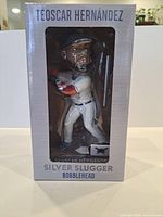 Front of boxed Teoscar Hernández bobblehead showing figure through window