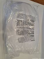 Factory-sealed white elongated toilet seat in clear plastic