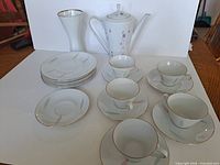 full view of coffee pot, cups, saucers, plates and vase