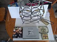 All items laid out: wine rack, Mantles opener box, cheese knife set box, bottle holder, ceramic tray, coasters