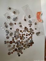 Overhead view showing large quantity of mixed world coins in coin flips and loose