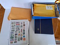 Albums, envelopes and box with stamp sheet visible