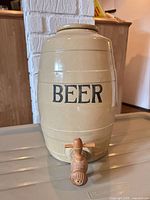 Front view of beige ceramic beer barrel with BEER text and wooden spigot