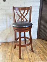 Front view of wood swivel bar stool showing lattice back and padded seat