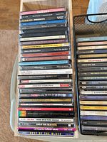 Wooden rack showing stack of CDs, visible titles include The B-52’s, Pet Shop Boys – Introspective, Katie Melua, Bon Jovi, ABBA