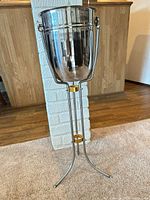 Full view of stainless steel champagne bucket on stand
