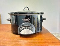 Front view of black Crock-Pot slow cooker showing lid, handles and control panel