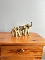 Two elephant figurines on wooden surface
