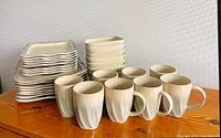 Full view of stacked plates, bowls and mugs making up the 32-piece dinnerware set
