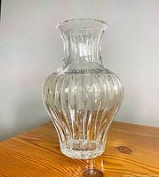 Full view of clear glass vase showing vertical fluted cuts and flared neck