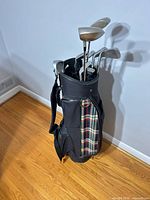Full view of golf bag standing on floor with clubs inserted