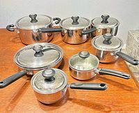 Full view of Lagostina stainless steel cookware set showing six pots and pans with five lids
