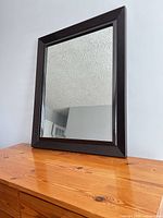 front view of rectangular wall mirror on dresser