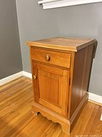 Full view of one nightstand front and side
