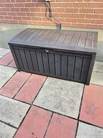 Closed resin deck box showing front panel and lid