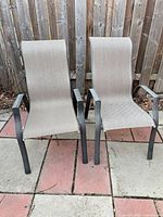 Two matching patio chairs showing overall design, materials, and condition