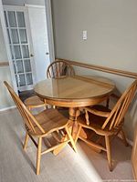 Round pedestal table with three chairs and stool