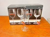 One boxed set of wine glasses with one glass displayed in front, indicates two total boxed sets